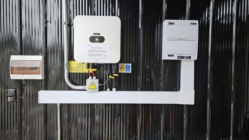 Dos inversores fotovoltaicos y tablero instalados en un galpón