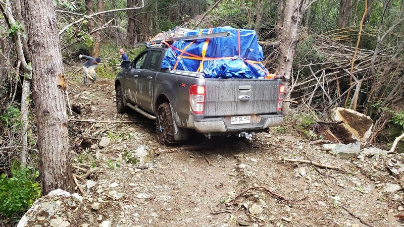 Camioneta cargada con módulos fotovoltaicos en un camino de bosque